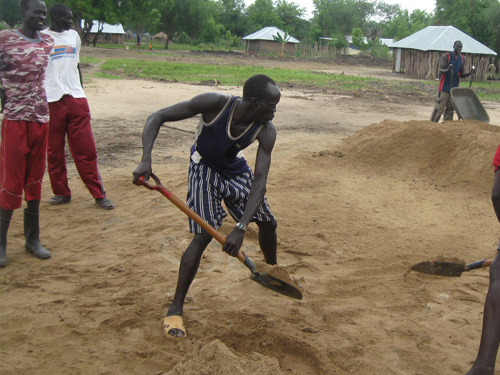 A man in black shirt and shorts playing baseball.