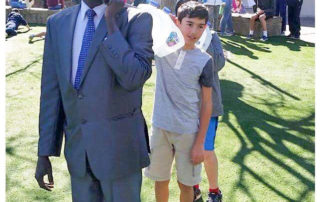 A man in a suit and tie standing next to a boy.