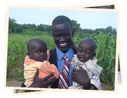 A man holding two young children in his arms.