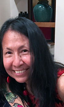 A woman with long black hair smiling for the camera.