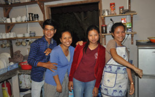 A group of people standing in a kitchen.