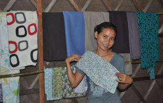 A woman holding up some fabric in front of a wall