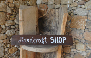 A sign that says handcraft shop on it.
