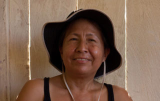 A woman wearing a hat and smiling for the camera.