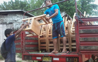 A man loading chairs into the back of a truck.