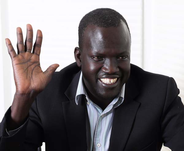 A man in a suit waving at the camera.