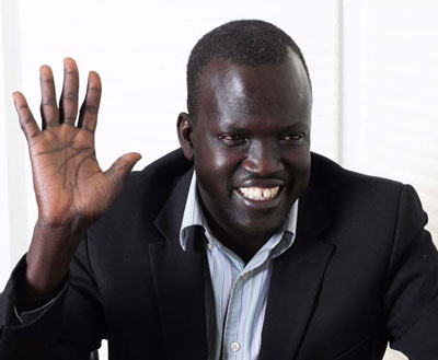 A man in a suit waving at the camera.