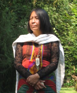 A woman in traditional clothing standing next to trees.