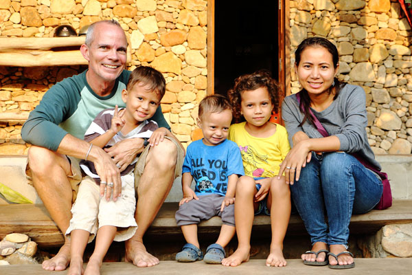 A family sitting on the steps of their home.