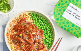 A bowl of rice and meat with peas.