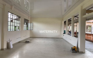 A large room with windows and a wall that says " maternity ".